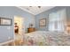 Comfortable bedroom with light blue walls and wood floors; doorway leads to patterned bathroom at 13130 50Th E Ct, Parrish, FL 34219
