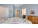 Comfortable bedroom with light blue walls, floral bedding, and en-suite bathroom entrance at 13130 50Th E Ct, Parrish, FL 34219