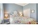 Charming bedroom with light blue walls, floral bedding, and white furniture at 13130 50Th E Ct, Parrish, FL 34219