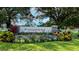 Landscaped community entrance sign with lush flowers and stone pillars creates a welcoming atmosphere at 13130 50Th E Ct, Parrish, FL 34219