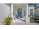 A charming front porch features a blue door, a bench, and elegant columns, creating a welcoming entrance at 13130 50Th E Ct, Parrish, FL 34219