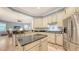 Bright, open kitchen with stainless steel appliances, granite counters, light cabinetry, and access to the living room at 13130 50Th E Ct, Parrish, FL 34219