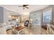 Open-concept living room with tile floors, plush seating, and views of the kitchen, dining area, and outdoor patio at 13130 50Th E Ct, Parrish, FL 34219