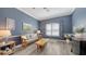 Bright living room with blue walls, white trim, modern flooring, and stylish decorations at 13130 50Th E Ct, Parrish, FL 34219
