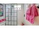 Modern shower with a black grid glass door, white subway tile, and pink floral accents at 13130 50Th E Ct, Parrish, FL 34219