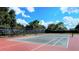 Outdoor tennis court with dark green screens providing shade for players to enjoy the game at 13130 50Th E Ct, Parrish, FL 34219