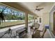 Covered patio with wicker seating, plants, and views of the fenced backyard at 13612 11Th E Ter, Bradenton, FL 34212
