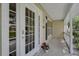 Cozy front porch featuring double glass doors, a welcoming mat, and stylish wall-mounted lanterns at 13612 11Th E Ter, Bradenton, FL 34212
