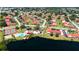 Aerial view showing the tennis courts, pool, and houses in a lush, green community near the lake at 1431 57Th W St # 1431, Bradenton, FL 34209