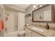 Updated bathroom featuring a granite vanity, bathtub, and tiled shower at 1431 57Th W St # 1431, Bradenton, FL 34209