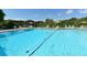 Sparkling community pool with chairs, tables and lake in the background at 1431 57Th W St # 1431, Bradenton, FL 34209