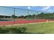Fenced-in tennis court with red and green surface provides a great space for recreational games at 1431 57Th W St # 1431, Bradenton, FL 34209
