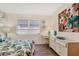 Well-lit bedroom features a large window, laminate floors, dresser and a queen-size bed at 1535 Pleasant Rd # H5, Bradenton, FL 34207