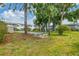 The community space features a park-like setting, lush green grass, mature trees, and a charming stone bench at 1535 Pleasant Rd # H5, Bradenton, FL 34207