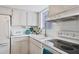 Bright kitchen with white cabinets, appliances, tile backsplash, and tile flooring at 1535 Pleasant Rd # H5, Bradenton, FL 34207