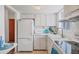 Bright kitchen with white cabinets, appliances, tile backsplash, and tile flooring at 1535 Pleasant Rd # H5, Bradenton, FL 34207