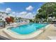 Sparkling community pool surrounded by ample seating and lush landscaping under a sunny sky at 1535 Pleasant Rd # H5, Bradenton, FL 34207