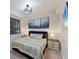 Cozy bedroom showcases a large bed, stylish chandelier, bedside tables and modern abstract art at 17704 Gawthrop Dr # 102, Bradenton, FL 34211