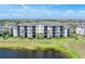 Exterior view of a multi-story condo building surrounded by manicured lawns and tranquil waters at 17704 Gawthrop Dr # 102, Bradenton, FL 34211