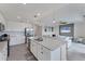 Open-concept kitchen features white cabinets, stainless appliances, quartz countertops, large island, and living area at 17704 Gawthrop Dr # 102, Bradenton, FL 34211