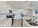 Modern kitchen boasts white cabinets, stainless steel appliances, quartz countertops and a center island with a double sink at 17704 Gawthrop Dr # 102, Bradenton, FL 34211