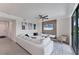 Modern living room featuring a large white sofa, wood accent wall, and ceiling fan at 17704 Gawthrop Dr # 102, Bradenton, FL 34211