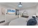 Bedroom features a queen-sized bed, contemporary decor, ceiling fan, dresser, and a beach scene on television at 17704 Gawthrop Dr # 102, Bradenton, FL 34211