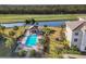 Aerial shot of a refreshing community pool with a charming gazebo, palm trees, and a golf course backdrop at 17704 Gawthrop Dr # 102, Bradenton, FL 34211