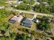 Aerial view of two homes with screened in pools, a long drive way, and lots of vegetation in the surrounding area at 18033 Edgewater Dr, Port Charlotte, FL 33948