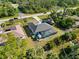 Aerial view of a home with a screened pool, long driveway, an RV and lots of trees around it and across the street at 18033 Edgewater Dr, Port Charlotte, FL 33948