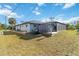 A lawn mower sits next to the shed and screened in lanai in this grassy, sunny backyard at 18033 Edgewater Dr, Port Charlotte, FL 33948