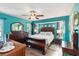 Inviting primary bedroom with a ceiling fan, wood floors, and bright teal walls at 18033 Edgewater Dr, Port Charlotte, FL 33948