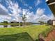 Scenic backyard view overlooking a tranquil lake with a well-maintained lawn and mature palm trees at 208 Potenza Loop, Nokomis, FL 34275