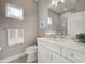 Bright bathroom featuring white cabinets, a gray tiled shower, and neutral décor at 208 Potenza Loop, Nokomis, FL 34275