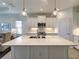 Modern kitchen island with stainless steel appliances and pendant lighting at 208 Potenza Loop, Nokomis, FL 34275