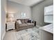 Cozy living space with a grey sofa, decorative pillows, a white side table, and a lamp at 208 Potenza Loop, Nokomis, FL 34275
