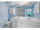 Bright bathroom with double vanity, white cabinets, and a mirror reflecting the view outside at 208 Silver Lake Dr # 101, Venice, FL 34292