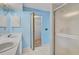 Bathroom featuring double sinks, white cabinets, shower and a walk-in closet at 208 Silver Lake Dr # 101, Venice, FL 34292