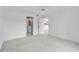 Empty bedroom with carpet and two visible doorways, one to a bathroom and the other to a kitchen at 208 Silver Lake Dr # 101, Venice, FL 34292