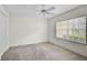 Bright bedroom with plush carpet, ceiling fan, and a window with blinds for ample natural light at 208 Silver Lake Dr # 101, Venice, FL 34292