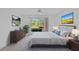 Staged bedroom with comfortable bed, dresser, bedside tables, and an outdoor view at 208 Silver Lake Dr # 101, Venice, FL 34292