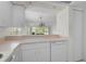 Bright kitchen featuring white appliances, cabinets, and an open view to a living area beyond the countertop at 208 Silver Lake Dr # 101, Venice, FL 34292