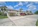 Exterior of a condo complex featuring covered parking, well-kept lawns, and access stairs to the units above at 208 Silver Lake Dr # 101, Venice, FL 34292