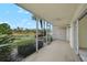 Enclosed patio overlooking lush greenery and serene pond with ceiling fan and sliding door at 208 Silver Lake Dr # 101, Venice, FL 34292