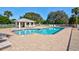Community pool features a poolside lounging area, surrounded by mature landscaping and a spacious brick paver deck at 208 Silver Lake Dr # 101, Venice, FL 34292