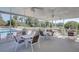 Community screened porch with tables and chairs overlooks a picturesque lake and pool at 208 Silver Lake Dr # 101, Venice, FL 34292