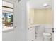 Bright bathroom featuring toilet, vanity, and access to exterior porch at 2196 Muskogee Trl, Nokomis, FL 34275
