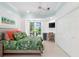 Bright bedroom featuring a desk area, storage, and a tropical comforter, with access to the outdoor patio at 2196 Muskogee Trl, Nokomis, FL 34275