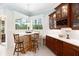 Bright breakfast nook featuring built-in seating, a custom table, and views of the lush outdoor greenery at 2196 Muskogee Trl, Nokomis, FL 34275
