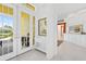 Bright entryway with double doors, white wainscoting, and transom windows for natural light at 2196 Muskogee Trl, Nokomis, FL 34275